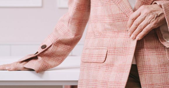 Fashion Careers - Woman in Pink and White Plaid Blazer Sitting on Brown Wooden Chair